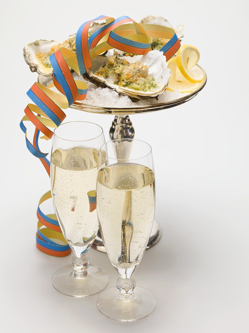 Oysters au gratin with paper streamer, glasses of sparkling wine