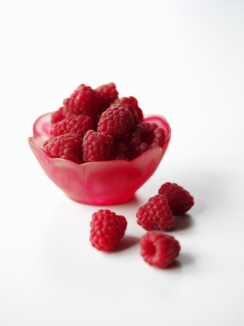 Raspberries in a red dish