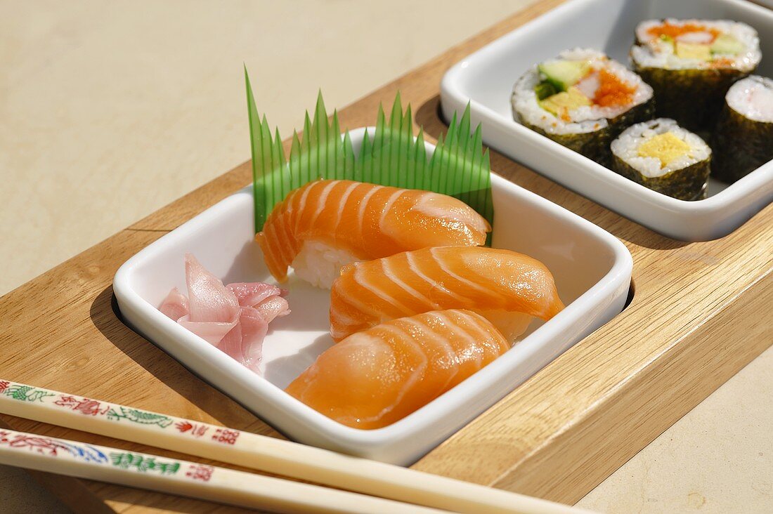 Assorted sushi in dishes with chopsticks