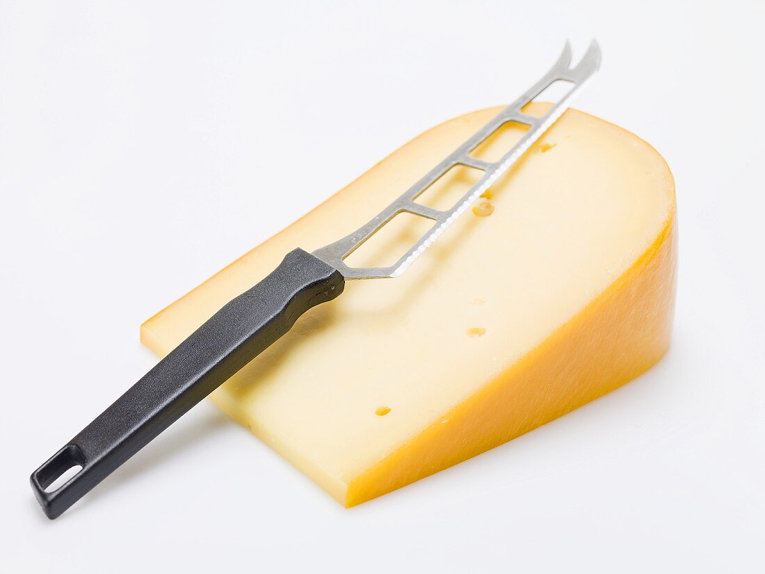 Stück Gouda mit Käsemesser