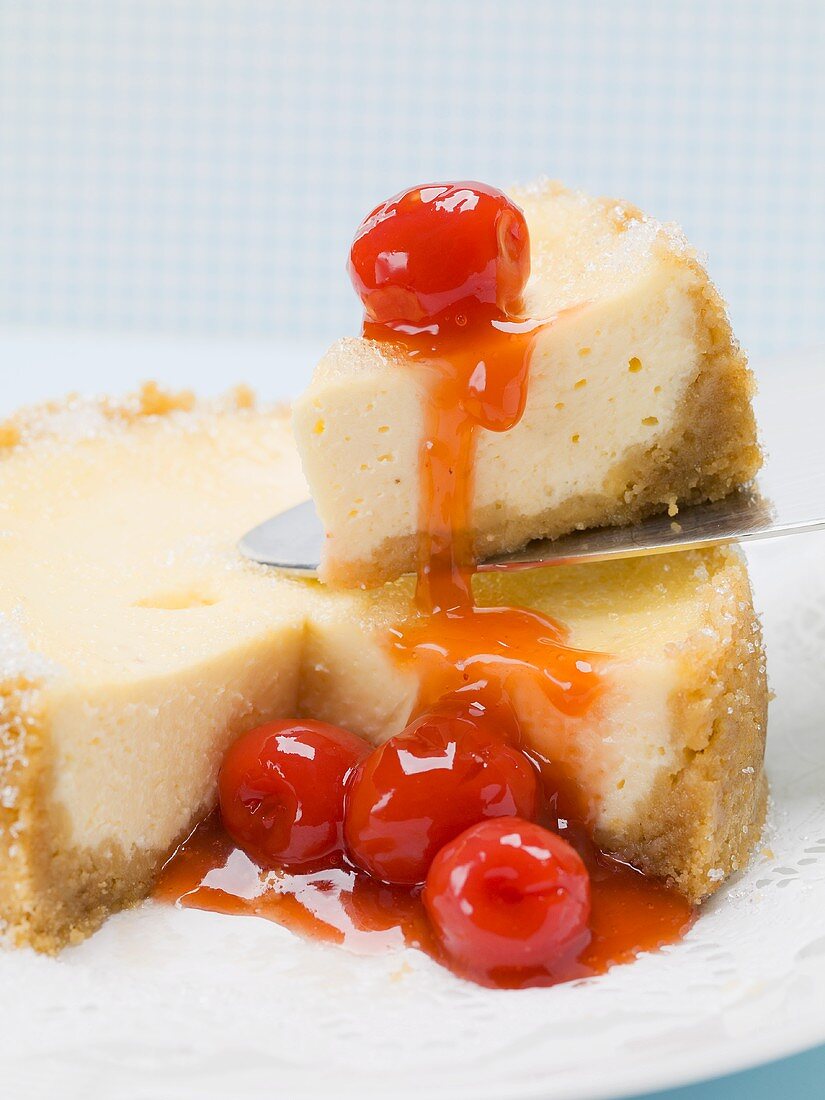 Small cheesecake with cocktail cherries, one piece on server