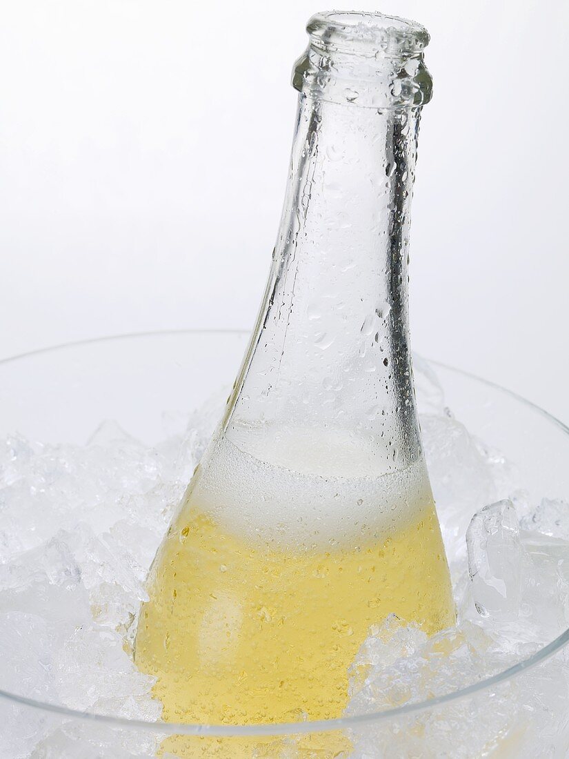 Open bottle of sparkling wine in ice bucket