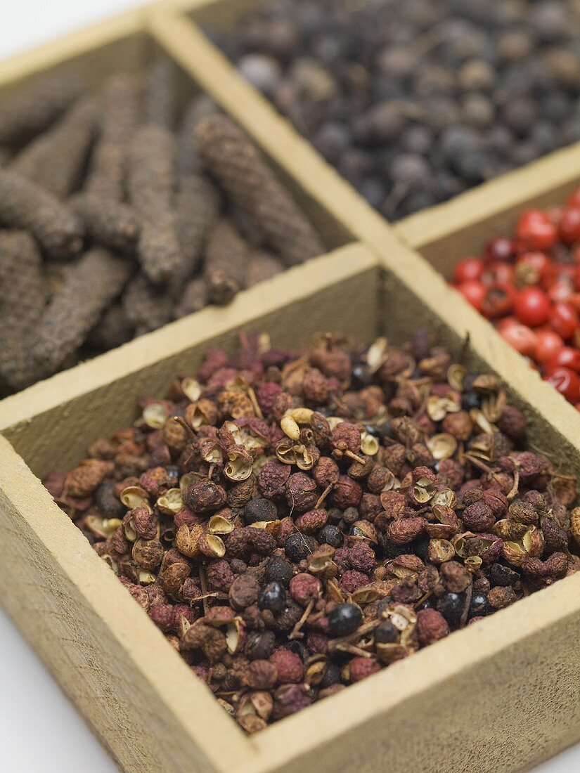 Spices and dried berries in wooden container