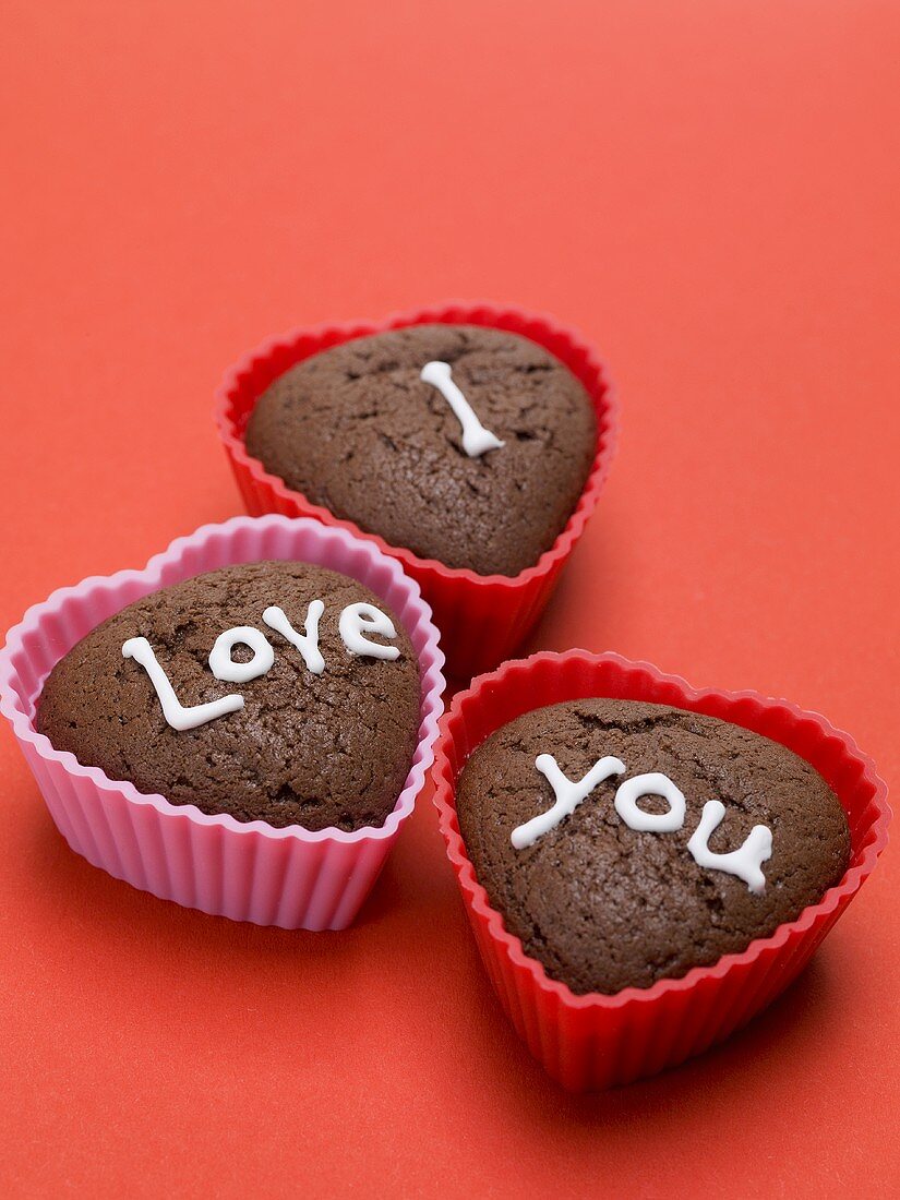 Heart-shaped chocolate muffins for lovers on red background