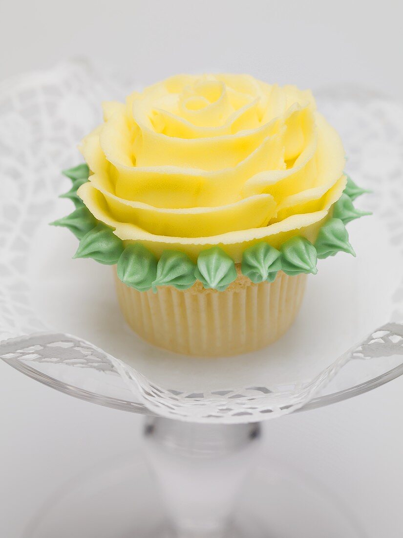 Yellow rose muffin on glass cake stand