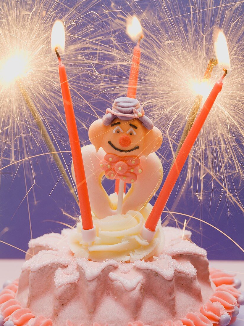 Small cake with clown & sparklers for child's birthday