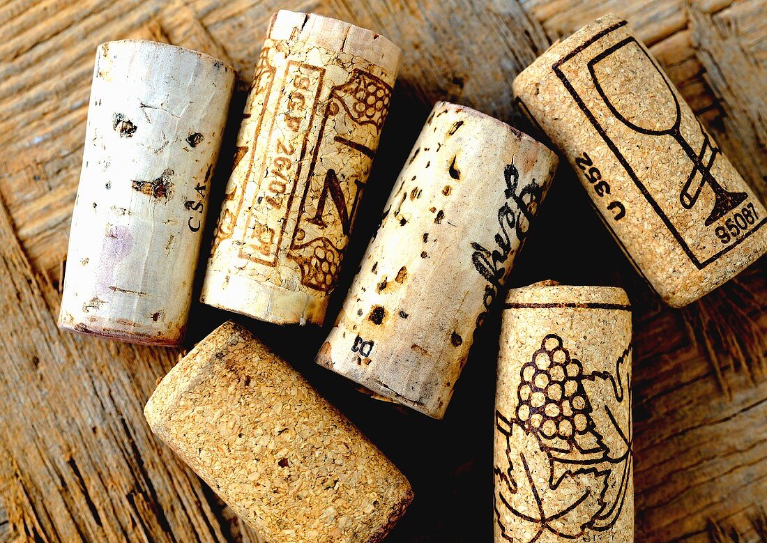 Verschiedene Weinkorken auf Holzuntergrund