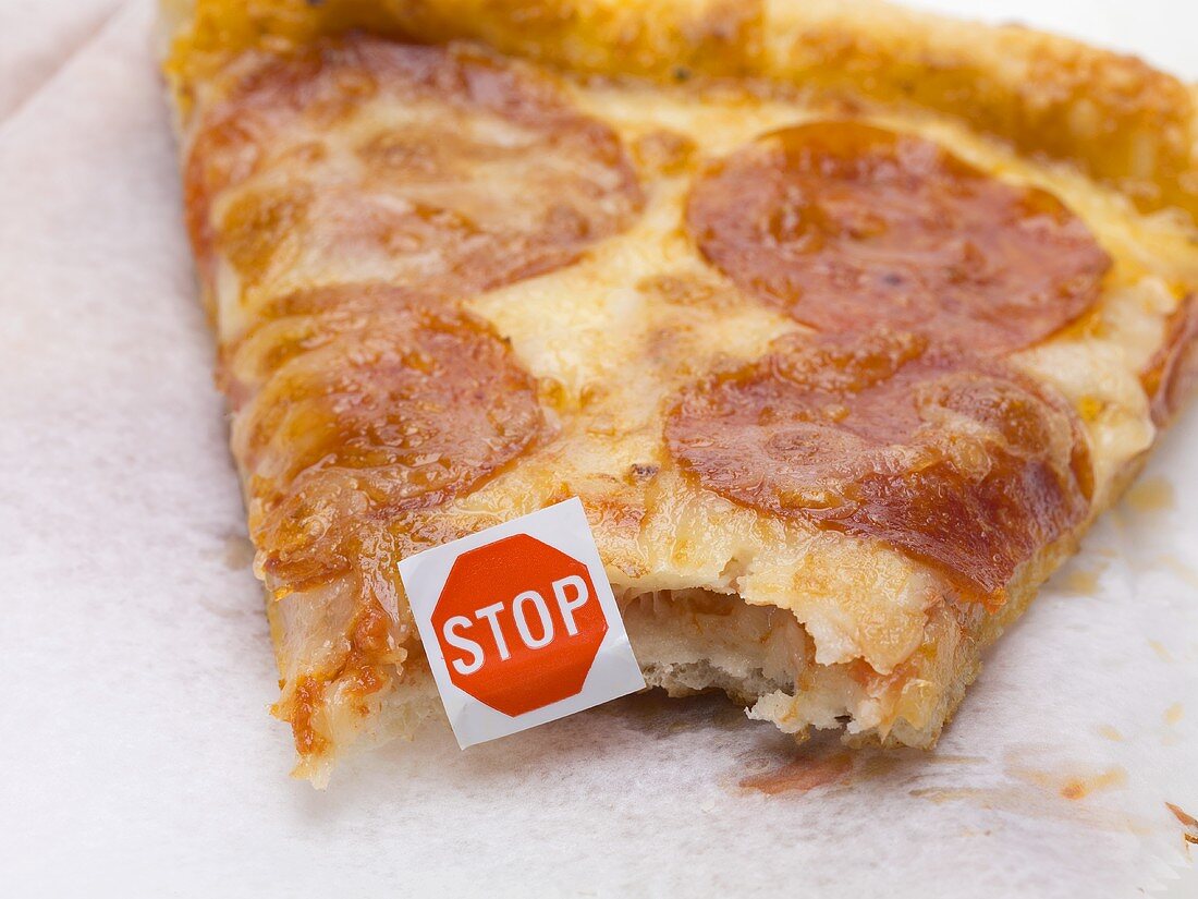 A slice of pizza with a 'Stop' sign