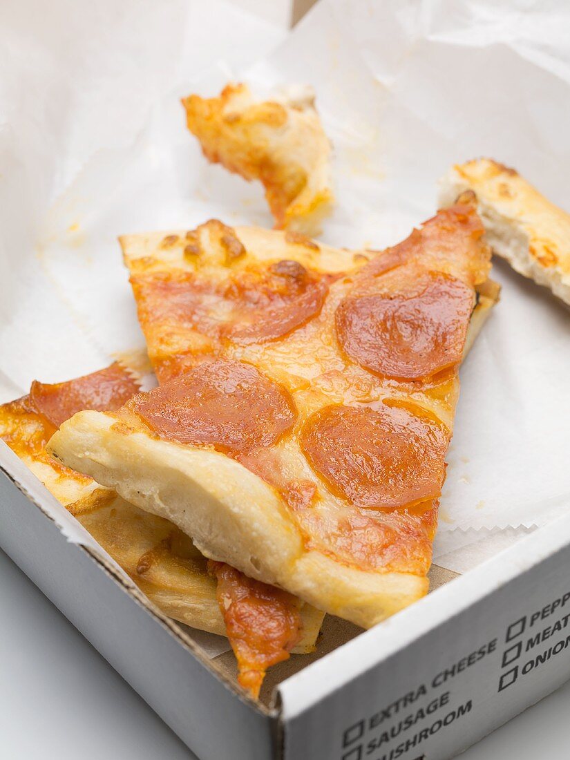 Several slices of pizza in a cardboard box