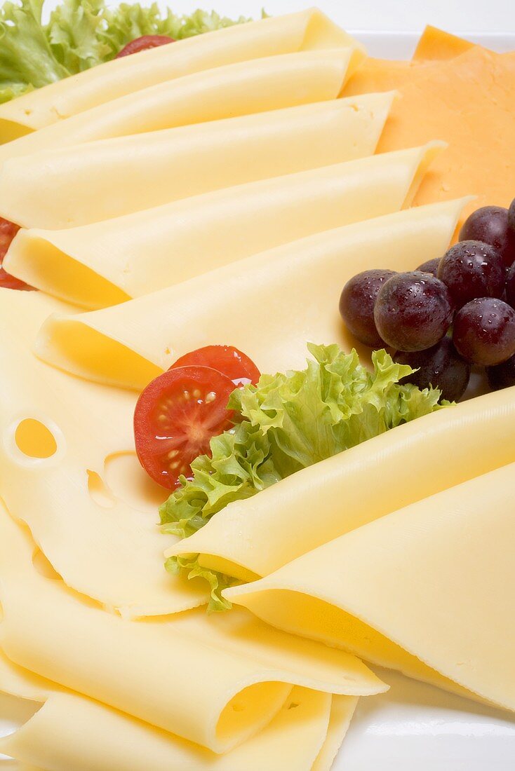Cheese platter with grapes, tomatoes and lettuce