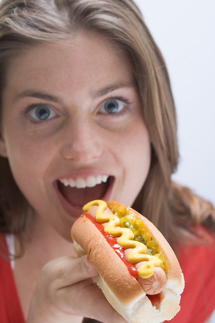 Frau beim Hot Dog mit Senf essen