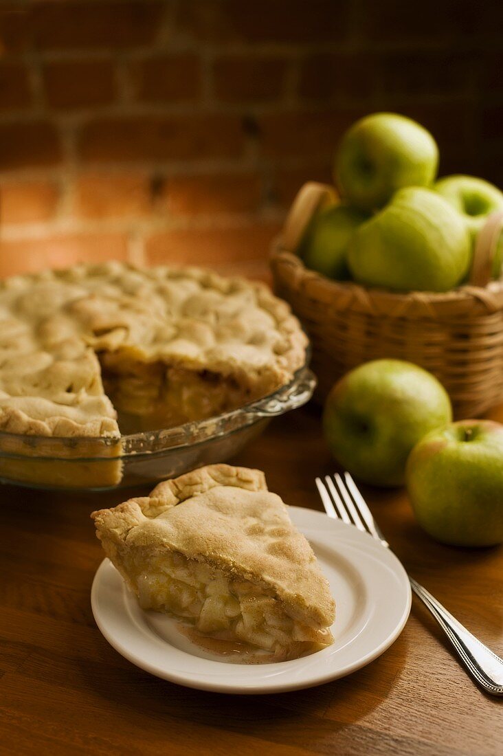 Slice of Homemade Apple Pie; Whole Pie in Background