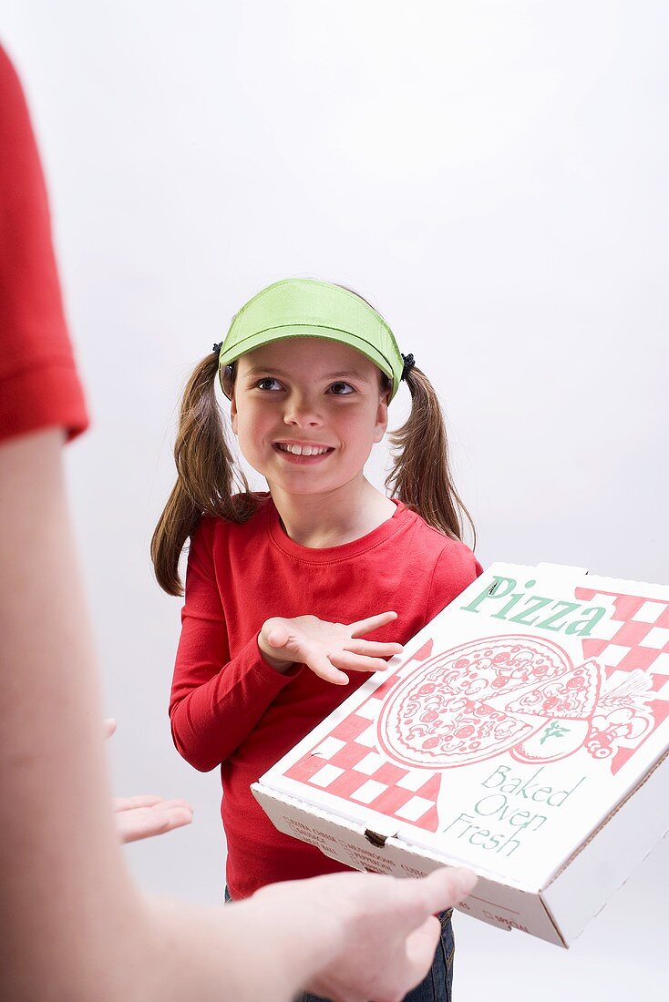 Girl in green sun visor showing pizza box