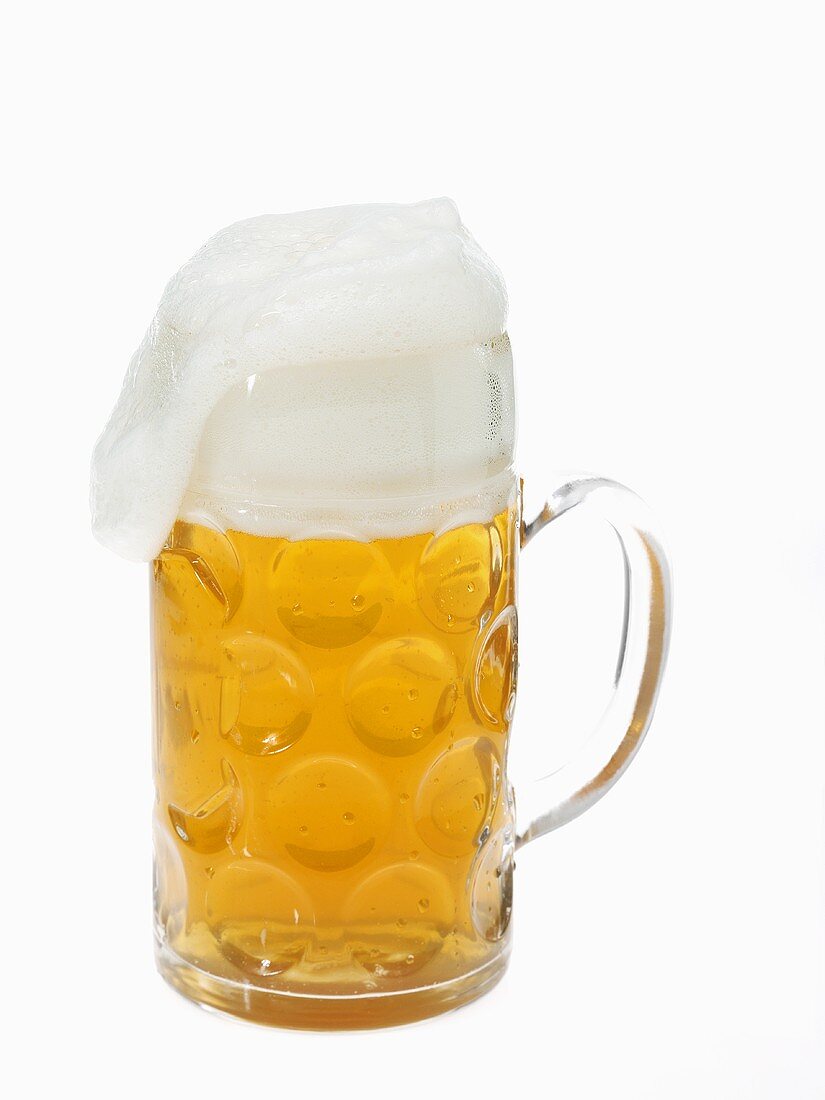 Beer in litre tankard with overflowing foam