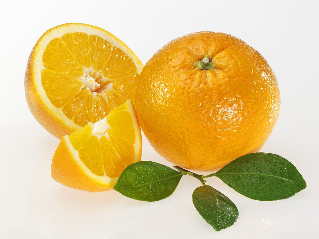 Orangen (ganz, halbiert und Schnitz) mit Blättern