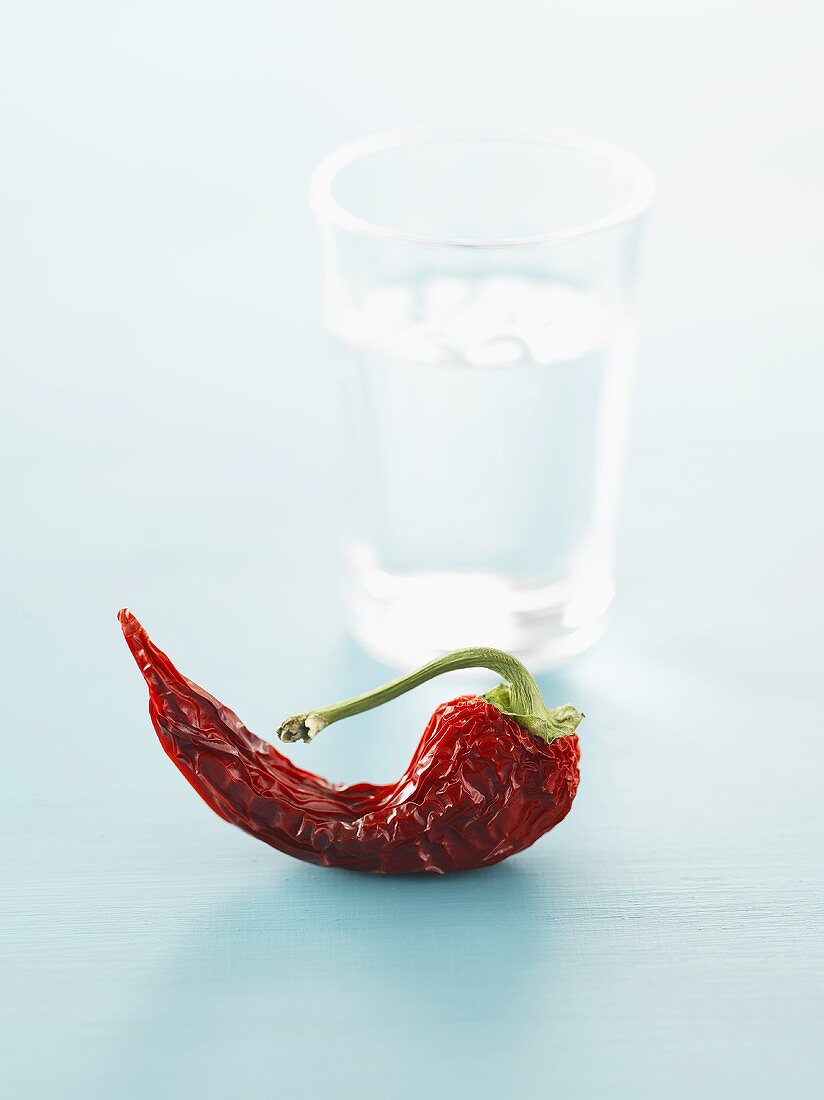 Dried chilli in front of glass of water