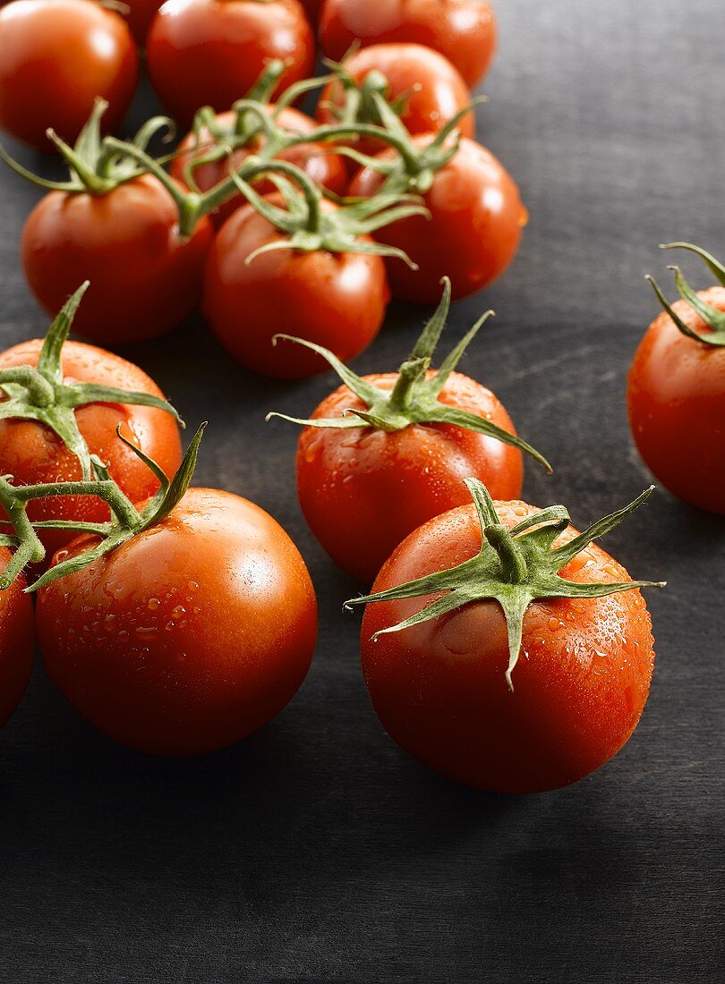 Several vine tomatoes with drops of water