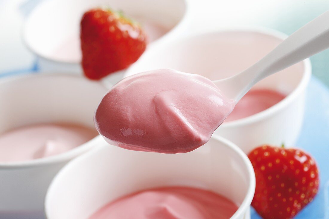 Strawberry yoghurt in pots and on spoon