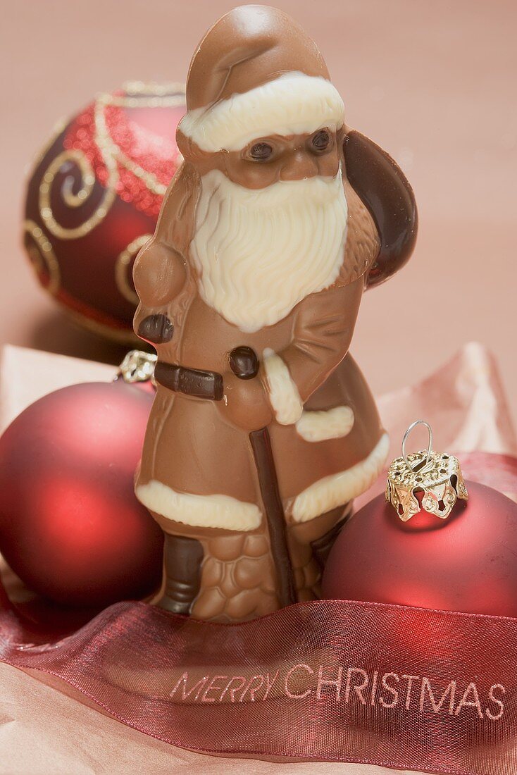 Weihnachtsmann aus Schokolade, rote Christbaumkugeln