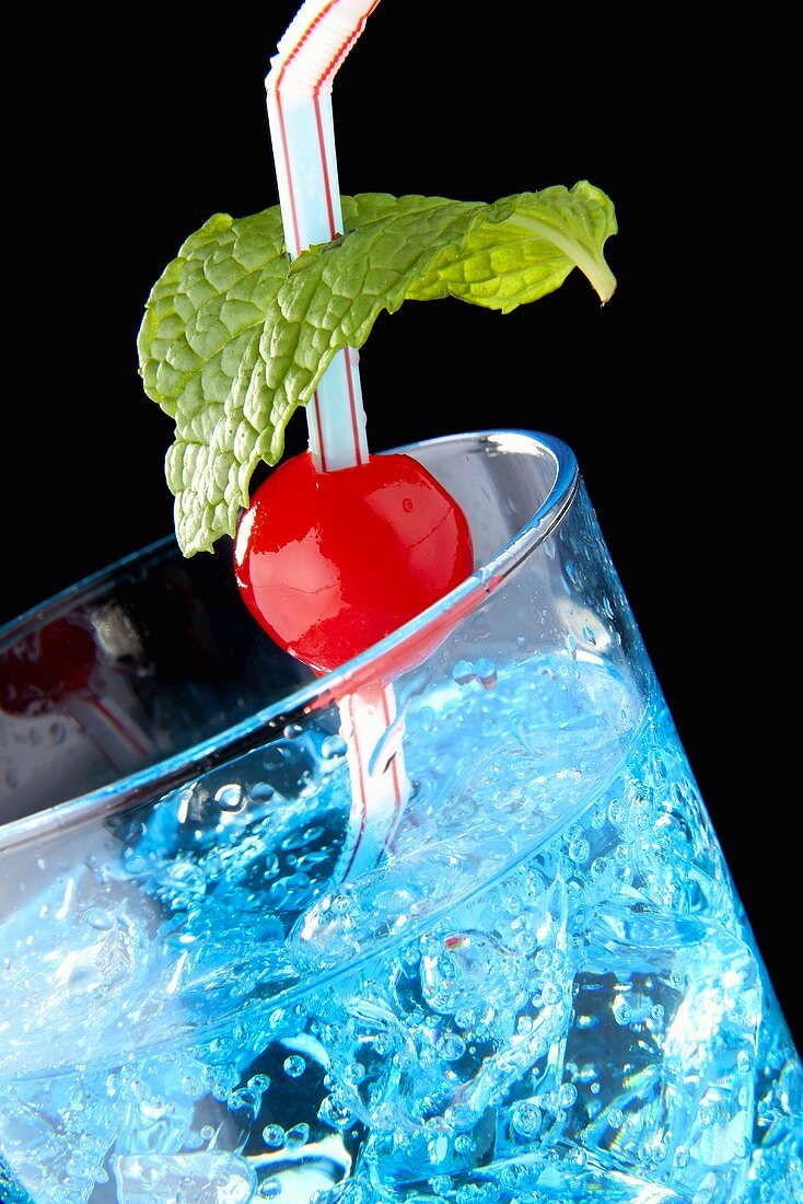 Oasis cocktail (gin, Blue Curacao, tonic water, crushed ice) with a cocktail cherry and mint