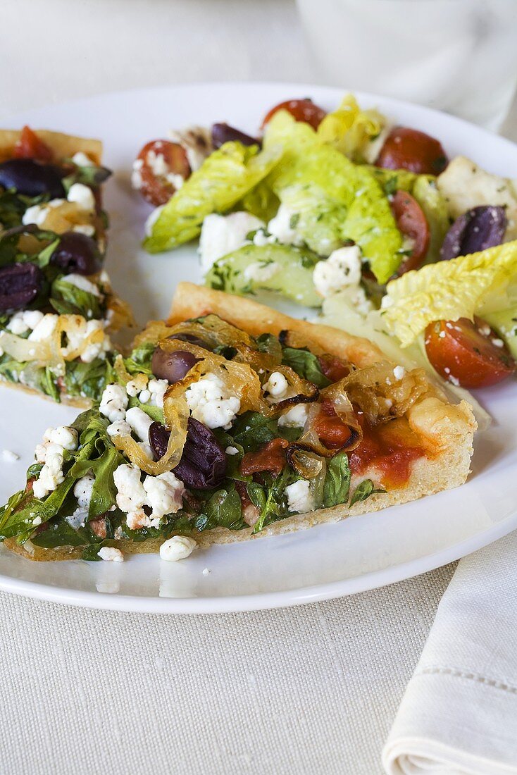 Pizza mit Rucola, Oliven, Feta und Salatbeilage