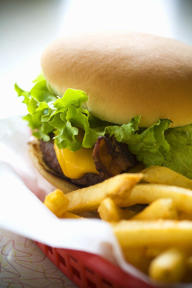 Cheeseburger mit Pommes frites im roten Korb