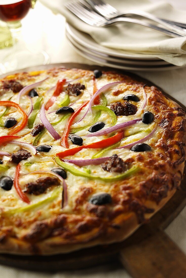 Sausage and Vegetable Pizza on Wooden Wheel