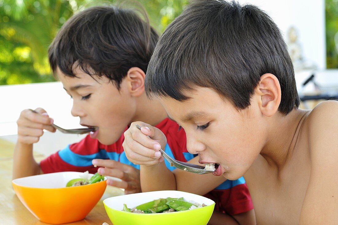 Two children eating soup