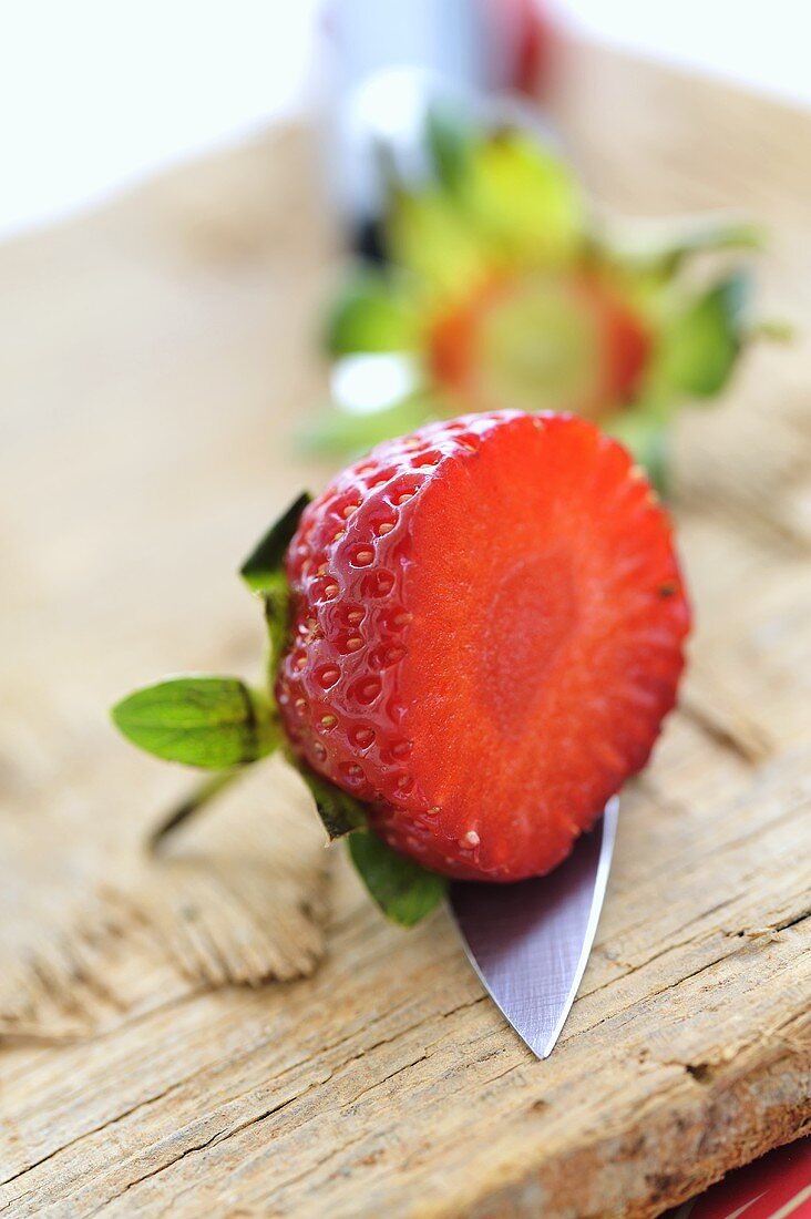 Erdbeerhälfte auf Messerspitze