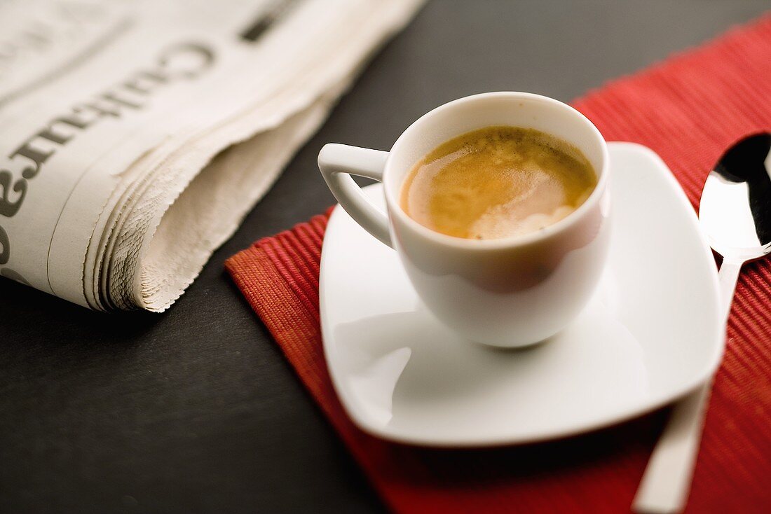 Eine Tasse Espresso mit Zeitung