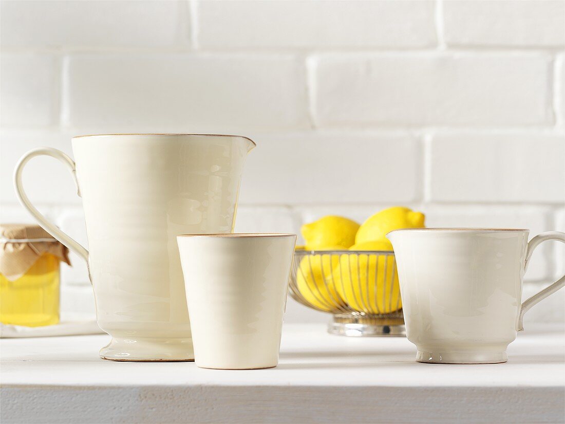 White ceramic jugs, lemons and honey