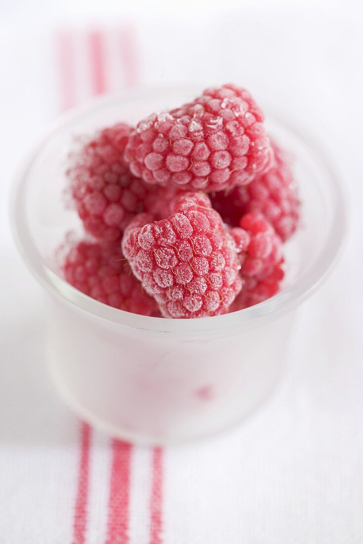 Frozen raspberries in glass
