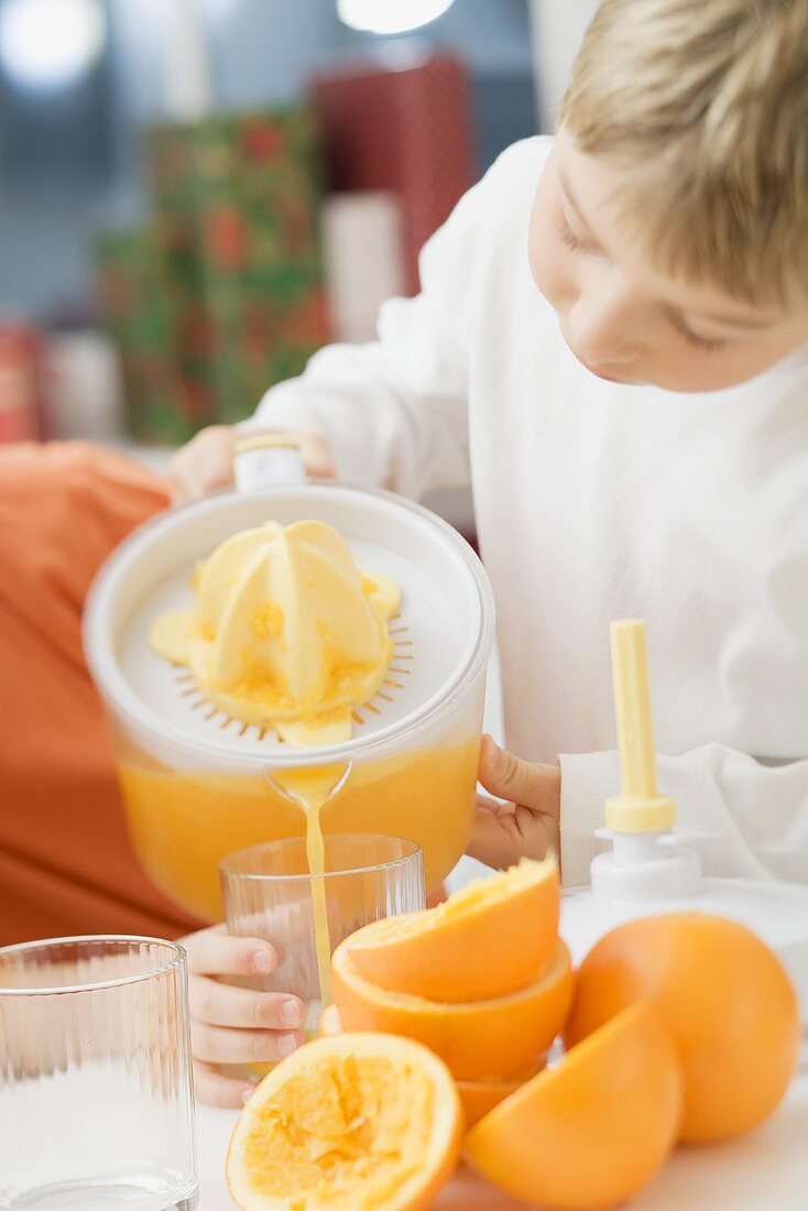 Kinder gießen frisch gepressten Orangensaft ins Glas
