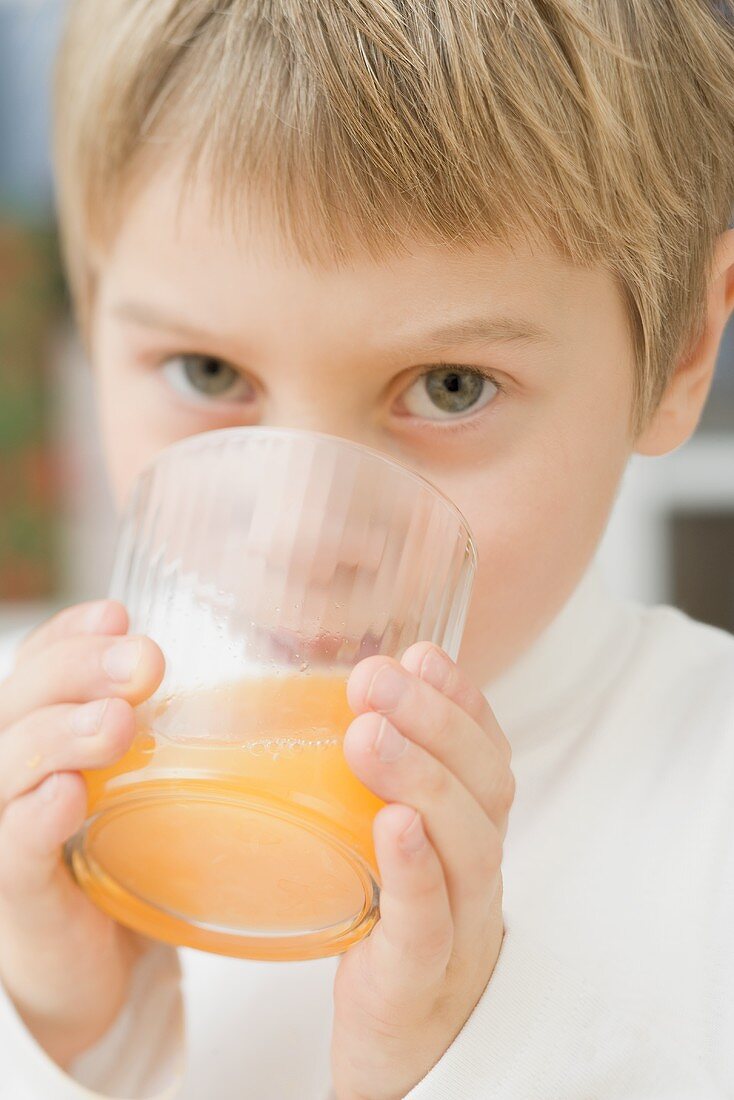 Kleiner Junge trinkt Orangensaft