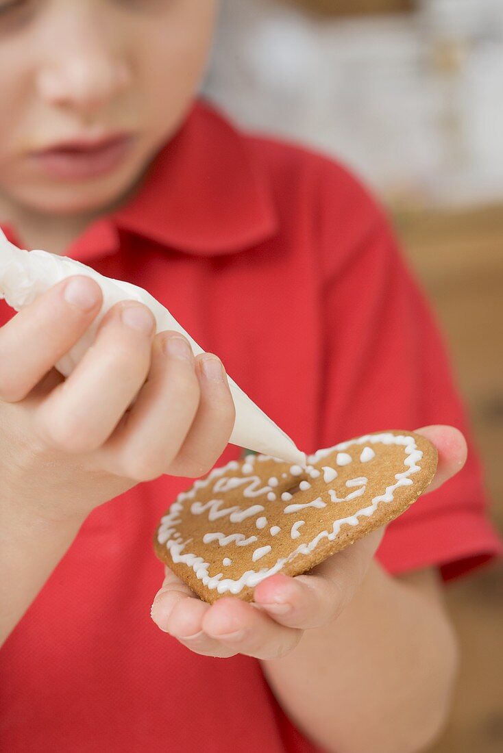 Child decorating biscuit with piping bag