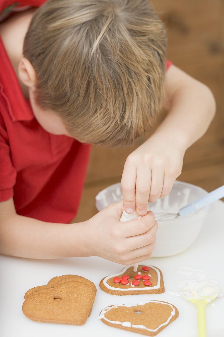 Little boy decorating biscuit