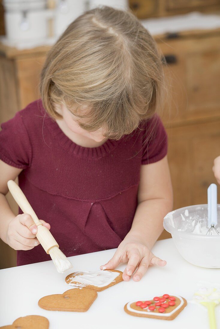 Little girl decorating biscuits