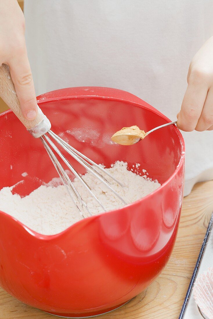 Child mixing flour and cinnamon
