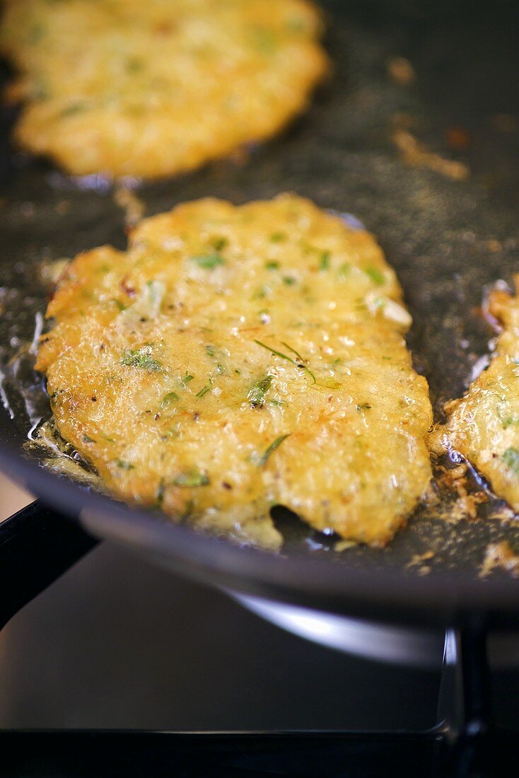 Frying prawn cakes in frying pan