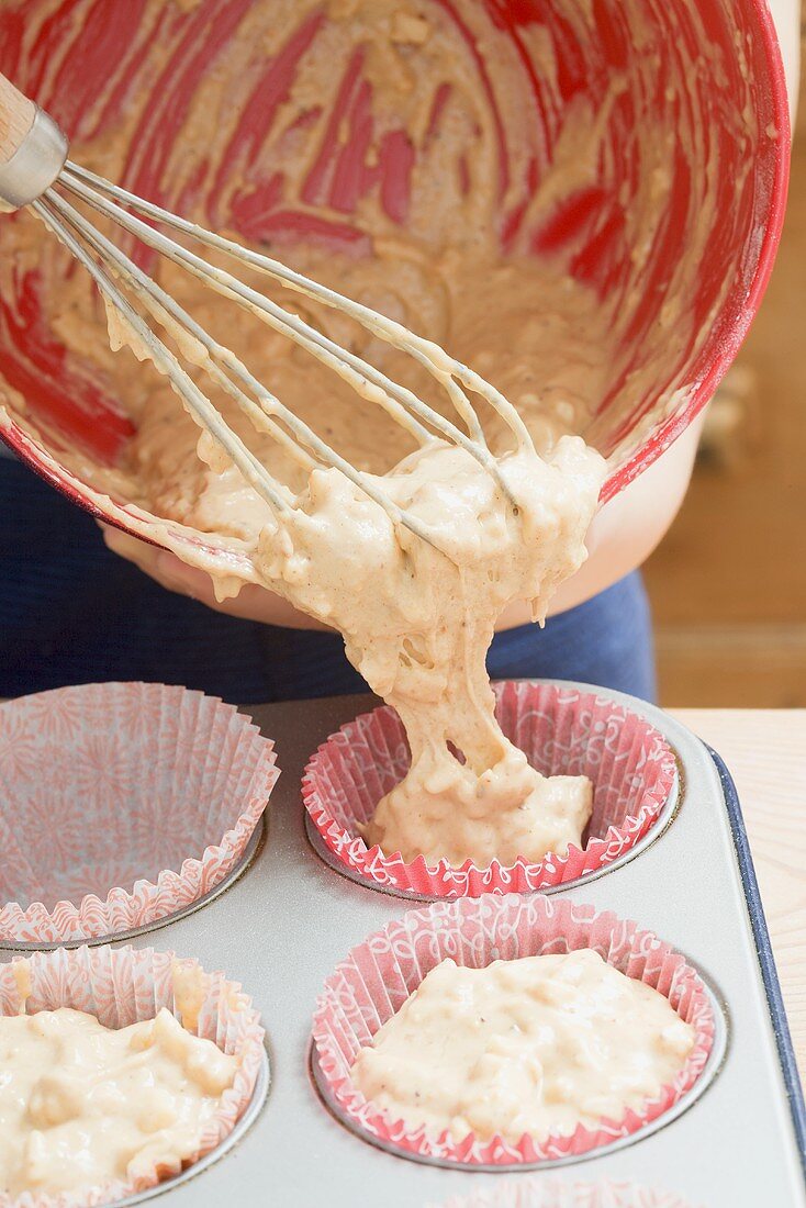 Putting muffin mixture into paper cases