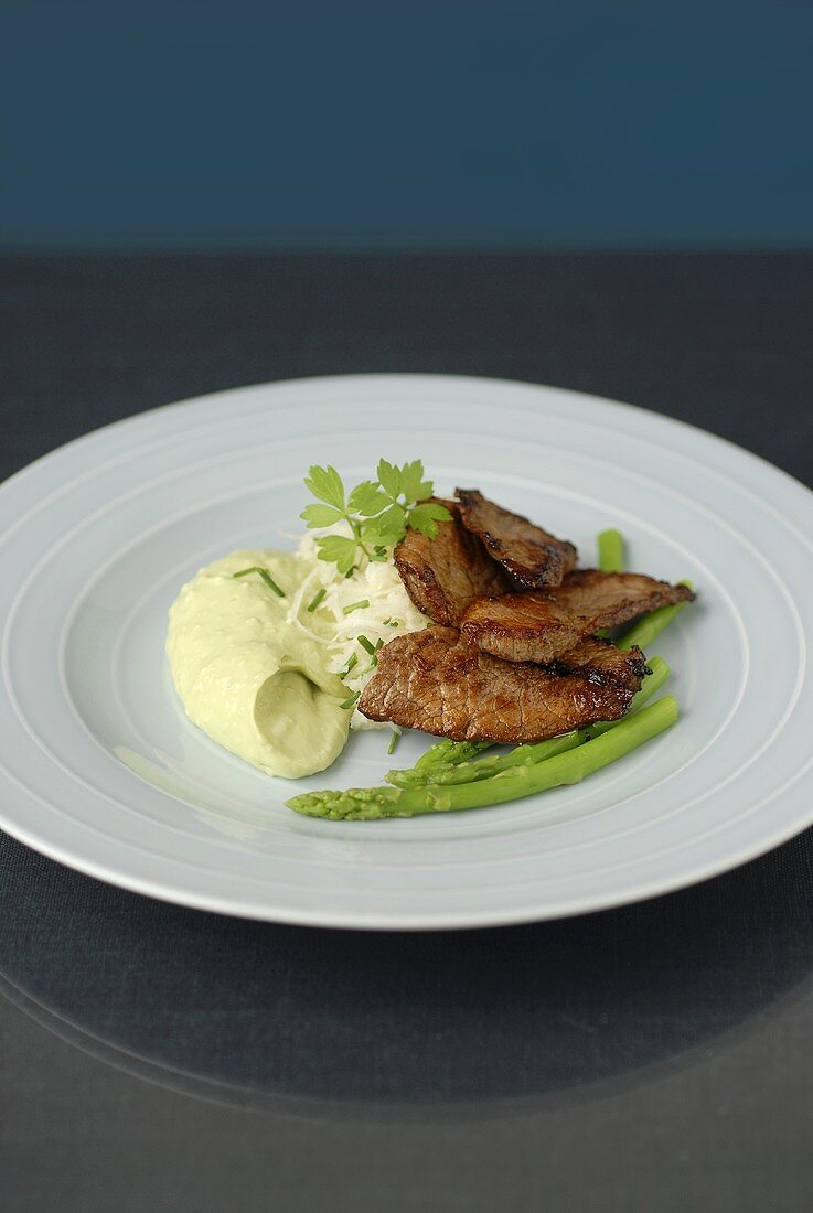 Beef with avocado cream and green asparagus