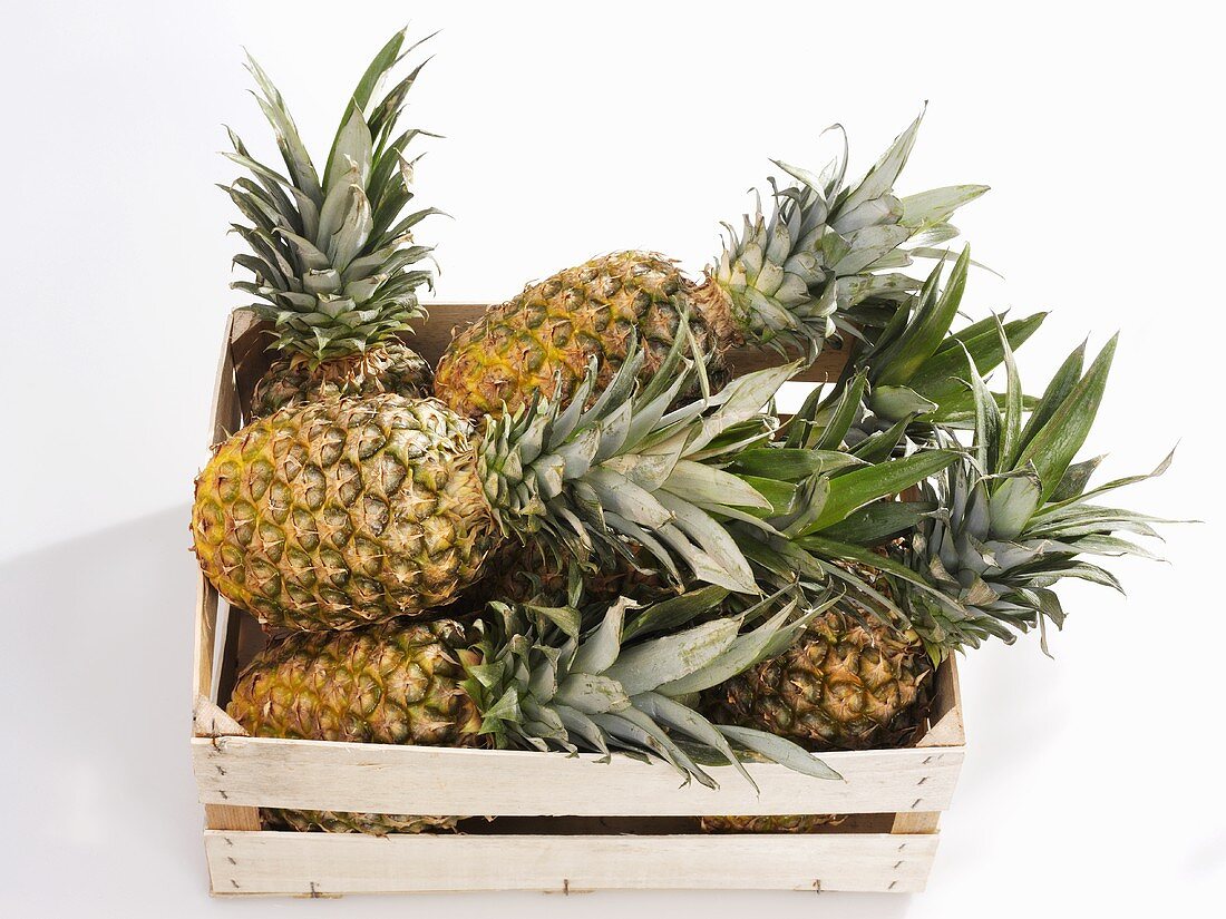 Several pineapples in a crate