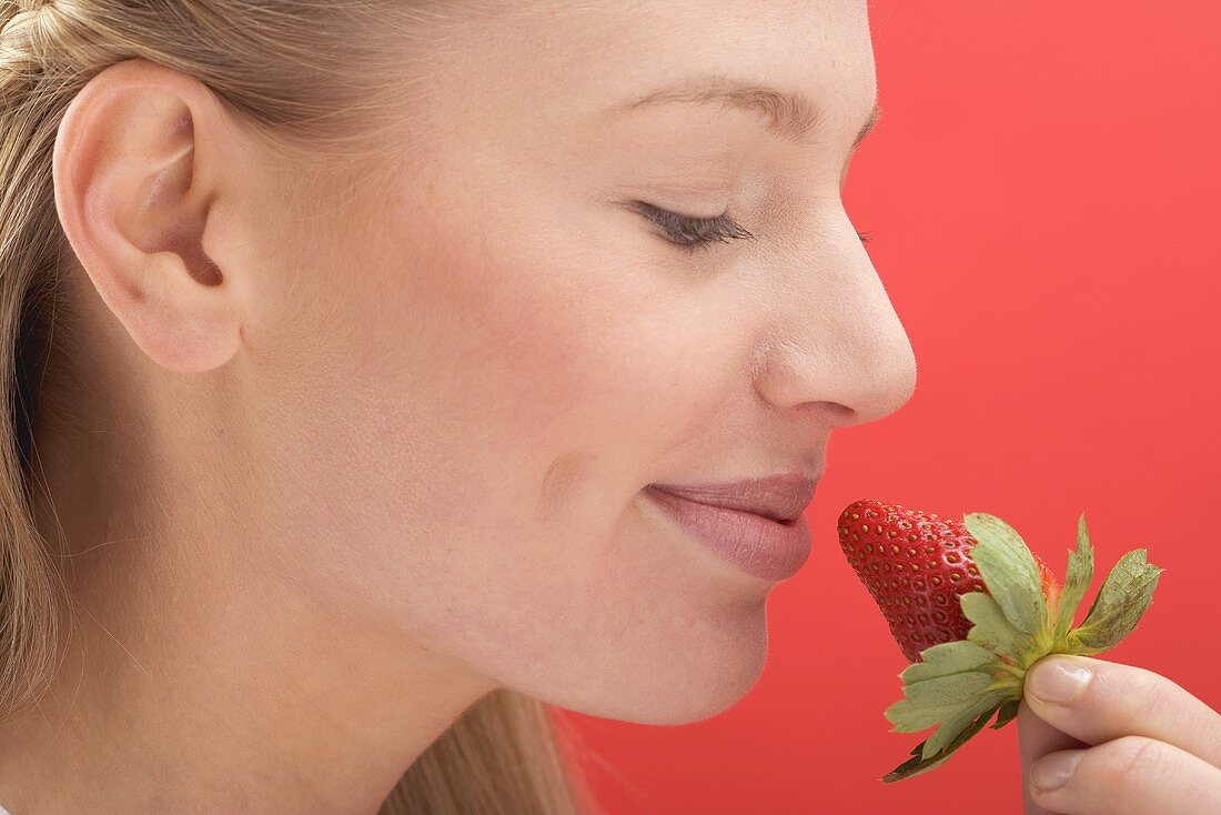 Frau hält Erdbeere