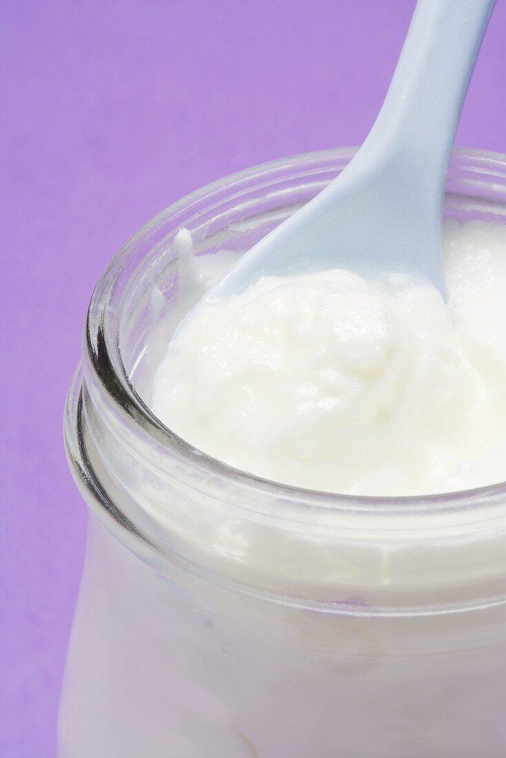 Yoghurt in jar with spoon (close-up)