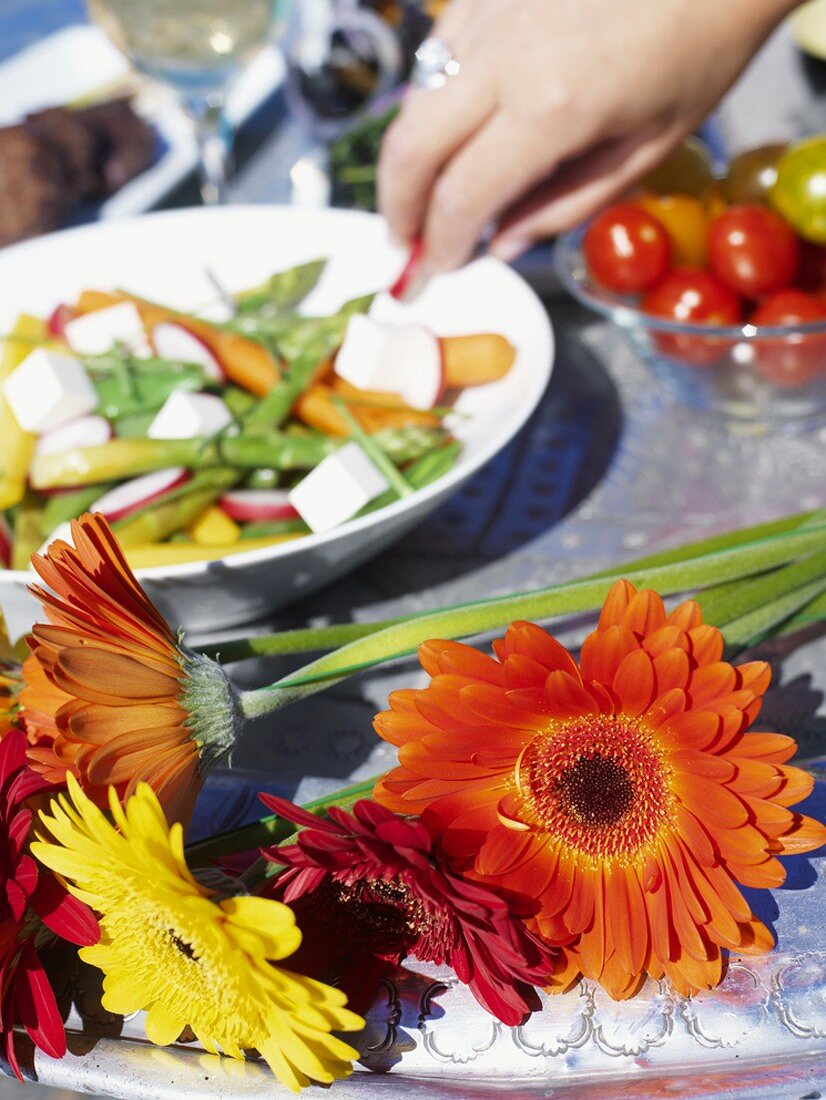 Gerbera und Gemüsesalat auf einem Tisch (Close Up)