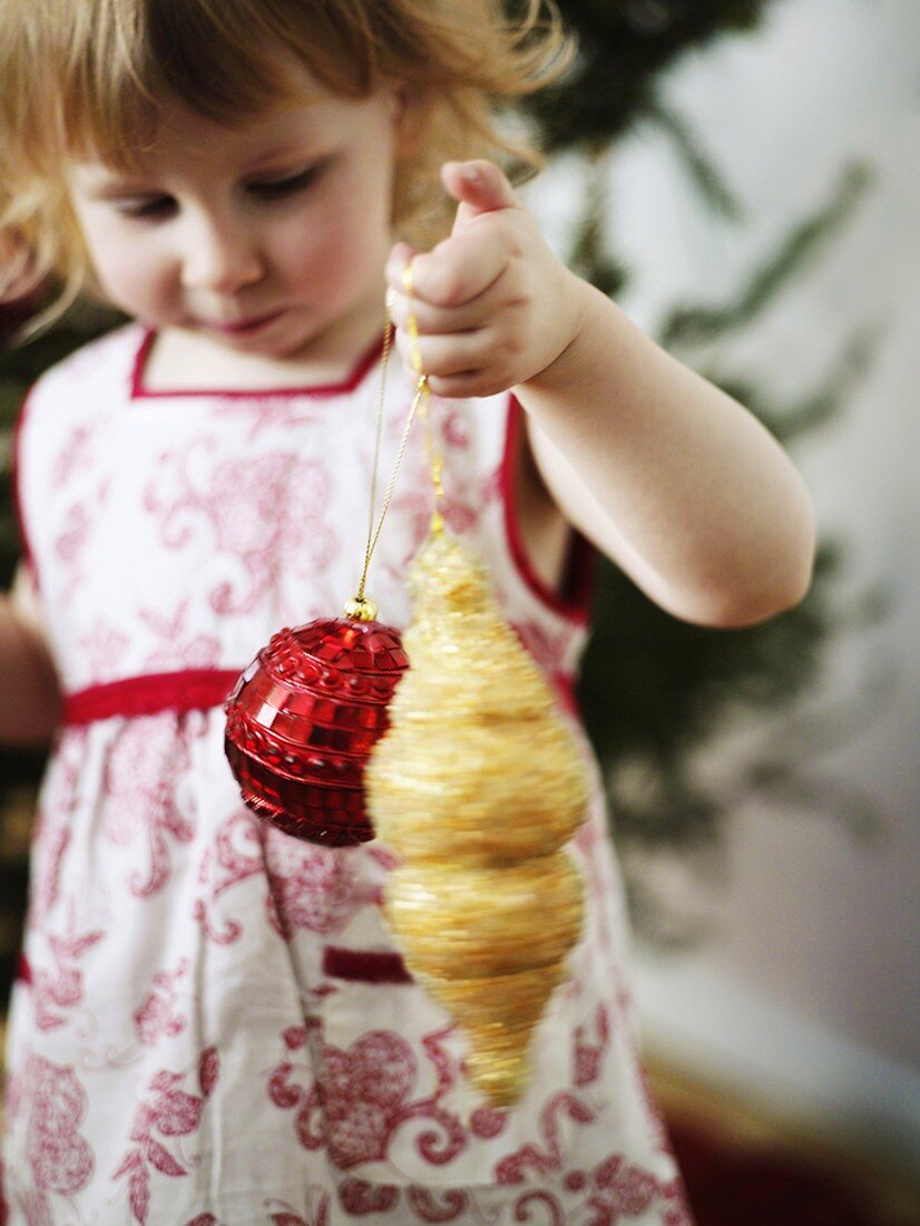 Little girl with Christmas tree ornaments