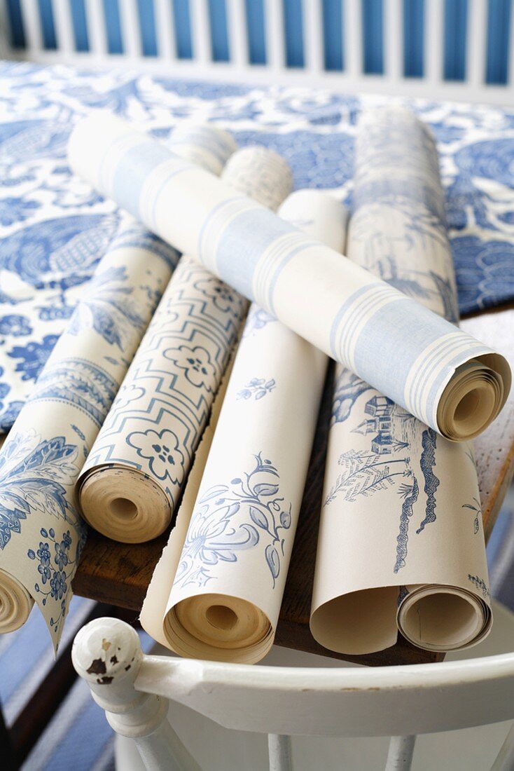 Rolls of blue and white patterned wallpaper