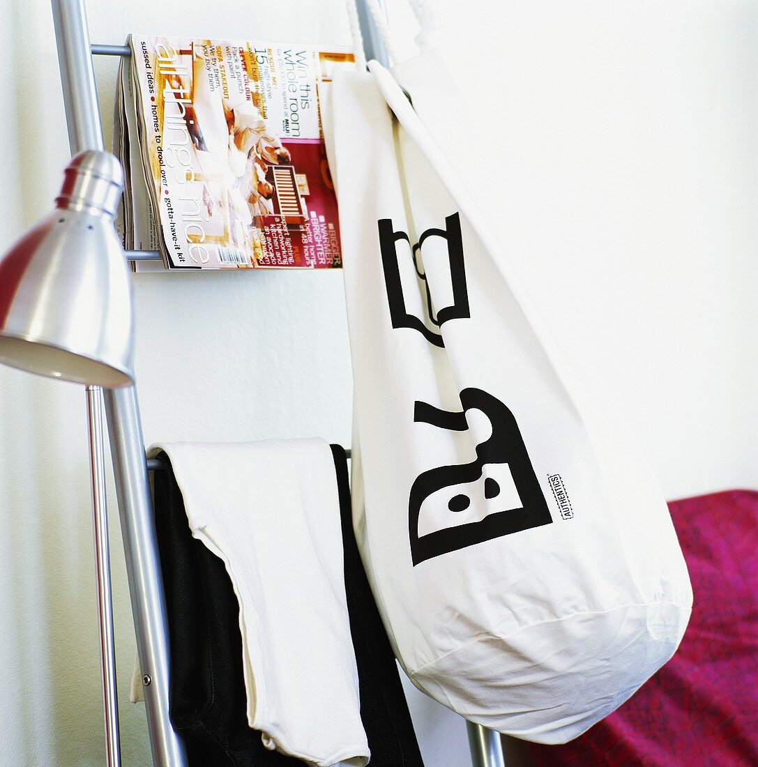 Standard lamp, clothes, magazine and laundry bag