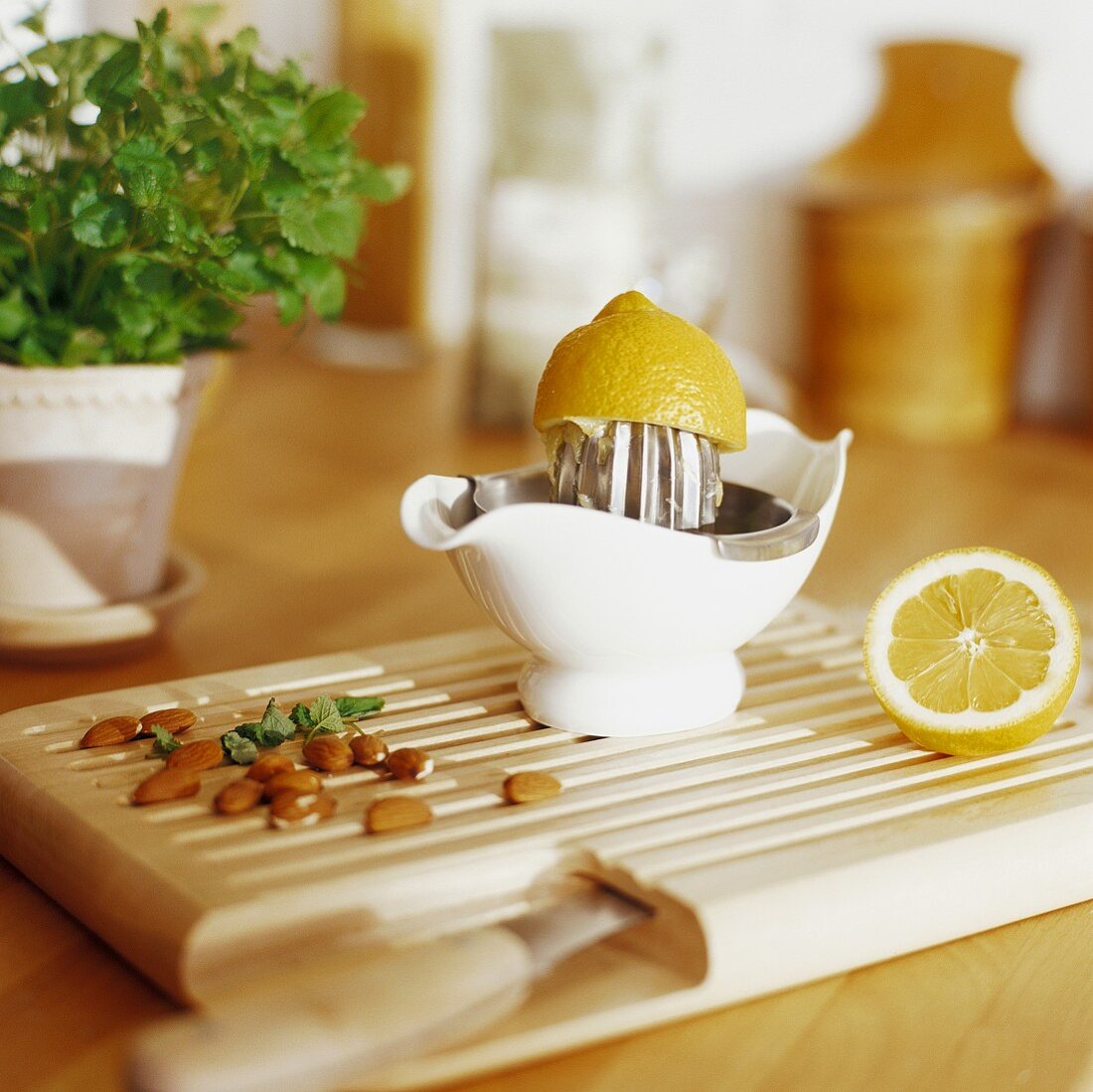 Lemon squeezer with lemon and almonds on a chopping board