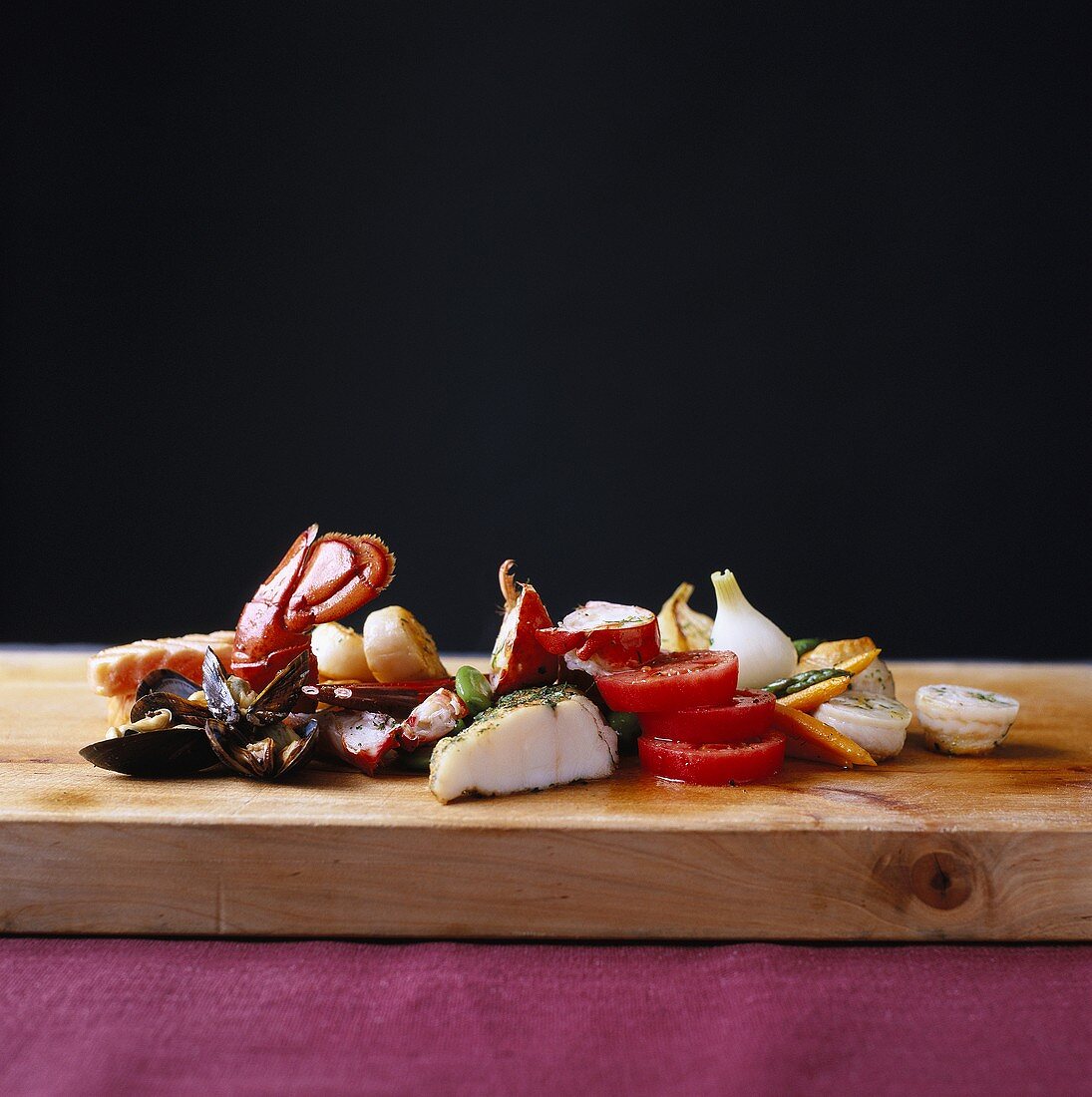 Seafood and vegetables on wooden board